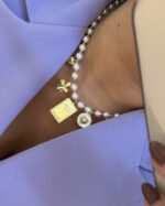 Colar pérolas com várias medalhas